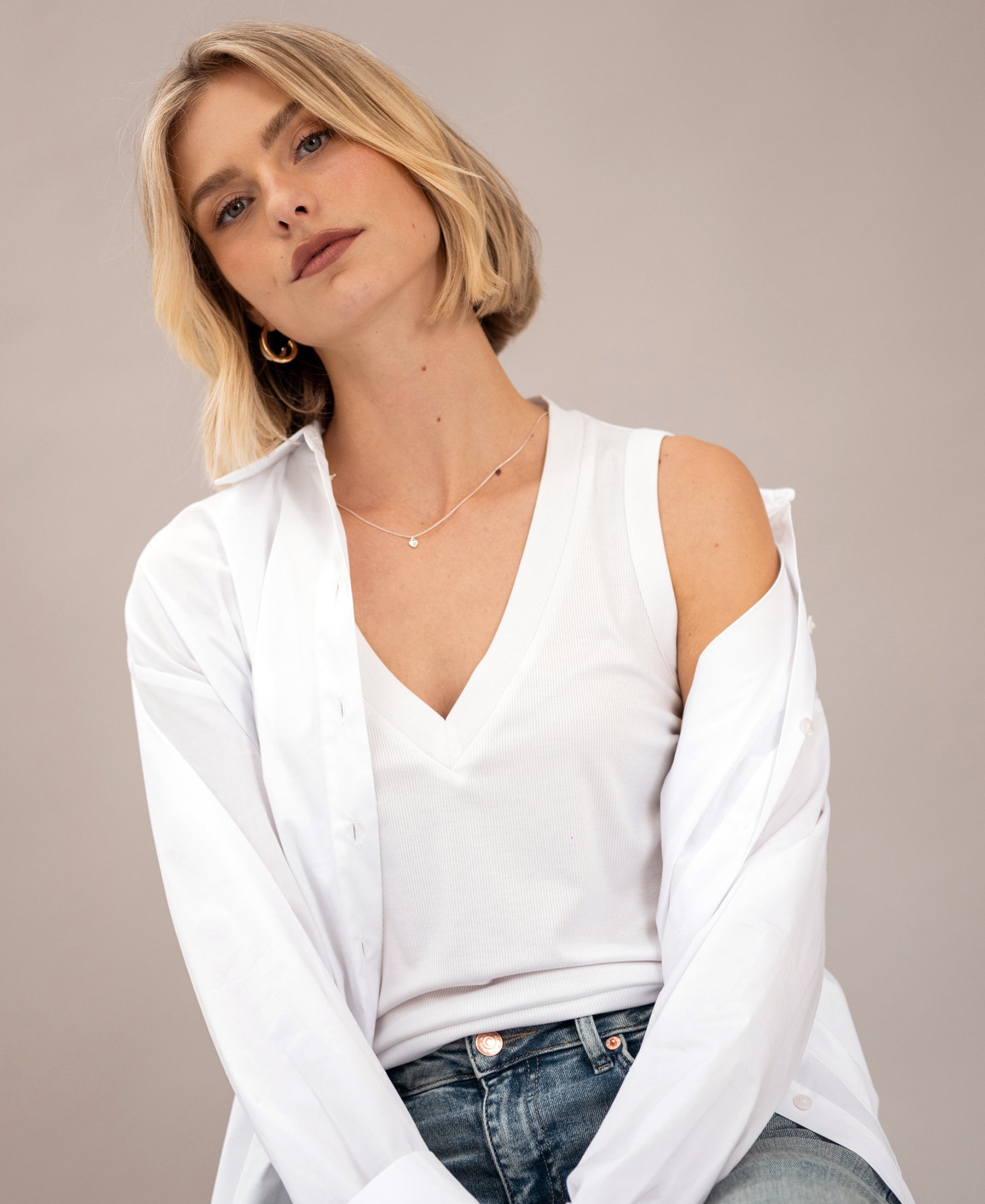 Woman wearing a white Lyocell top against a neutral background.