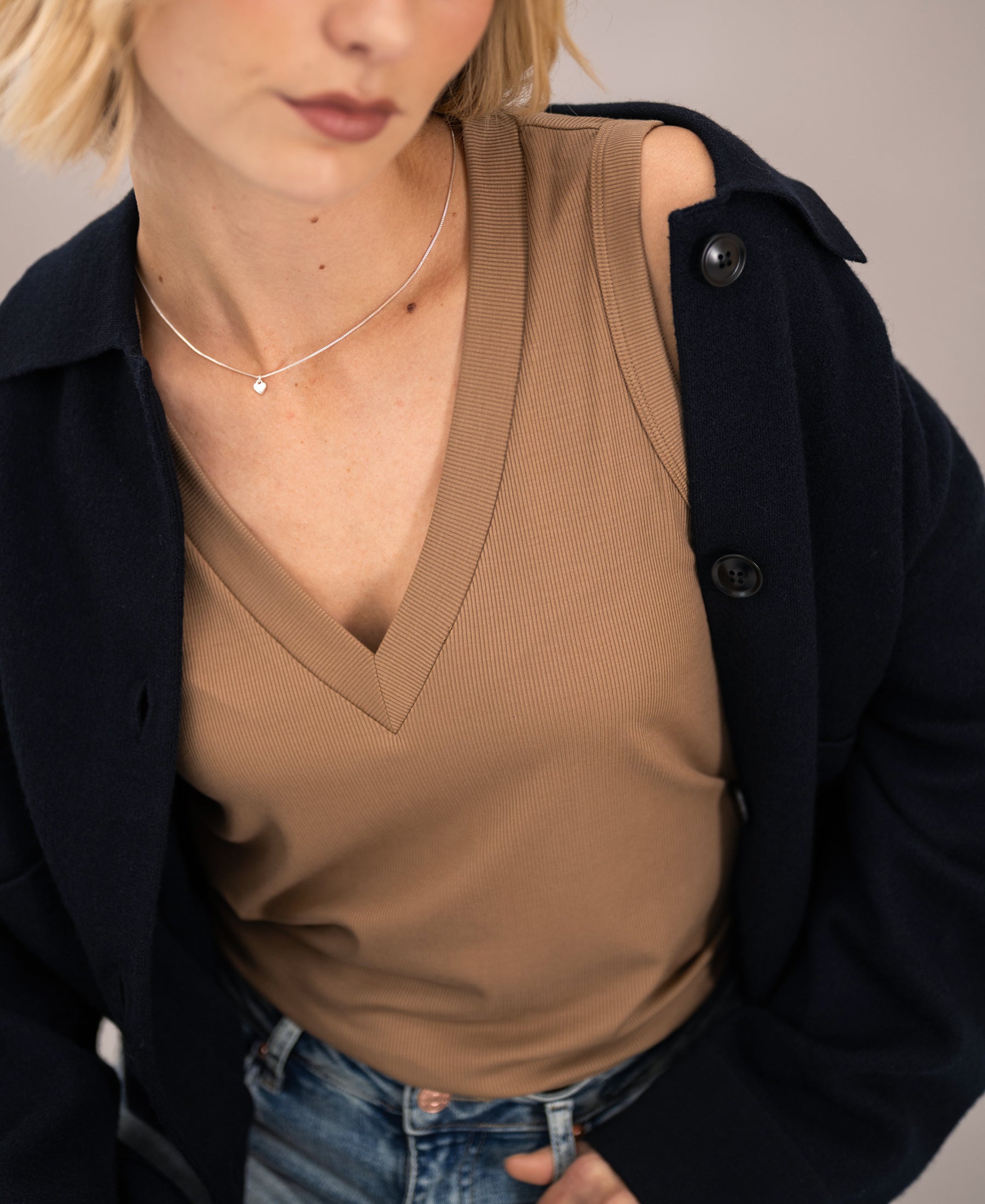 Woman wearing a walnut brown Lyocell top, shown from shoulders down.
