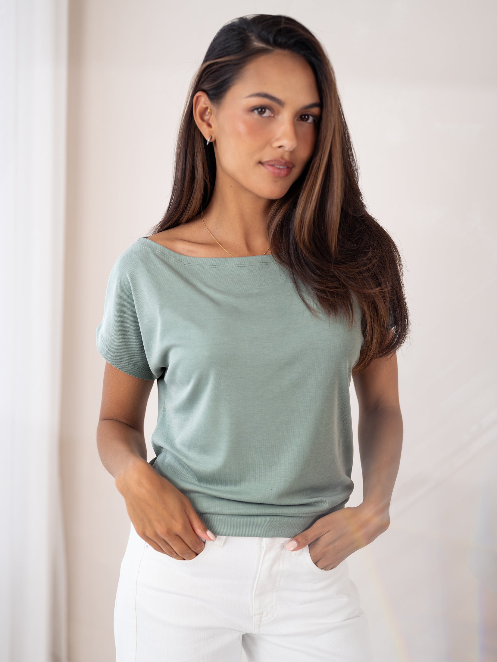 Light mist green rib boatneck T-shirt by PLEIN PUBLIQUE, shown worn by a woman with long brown hair.