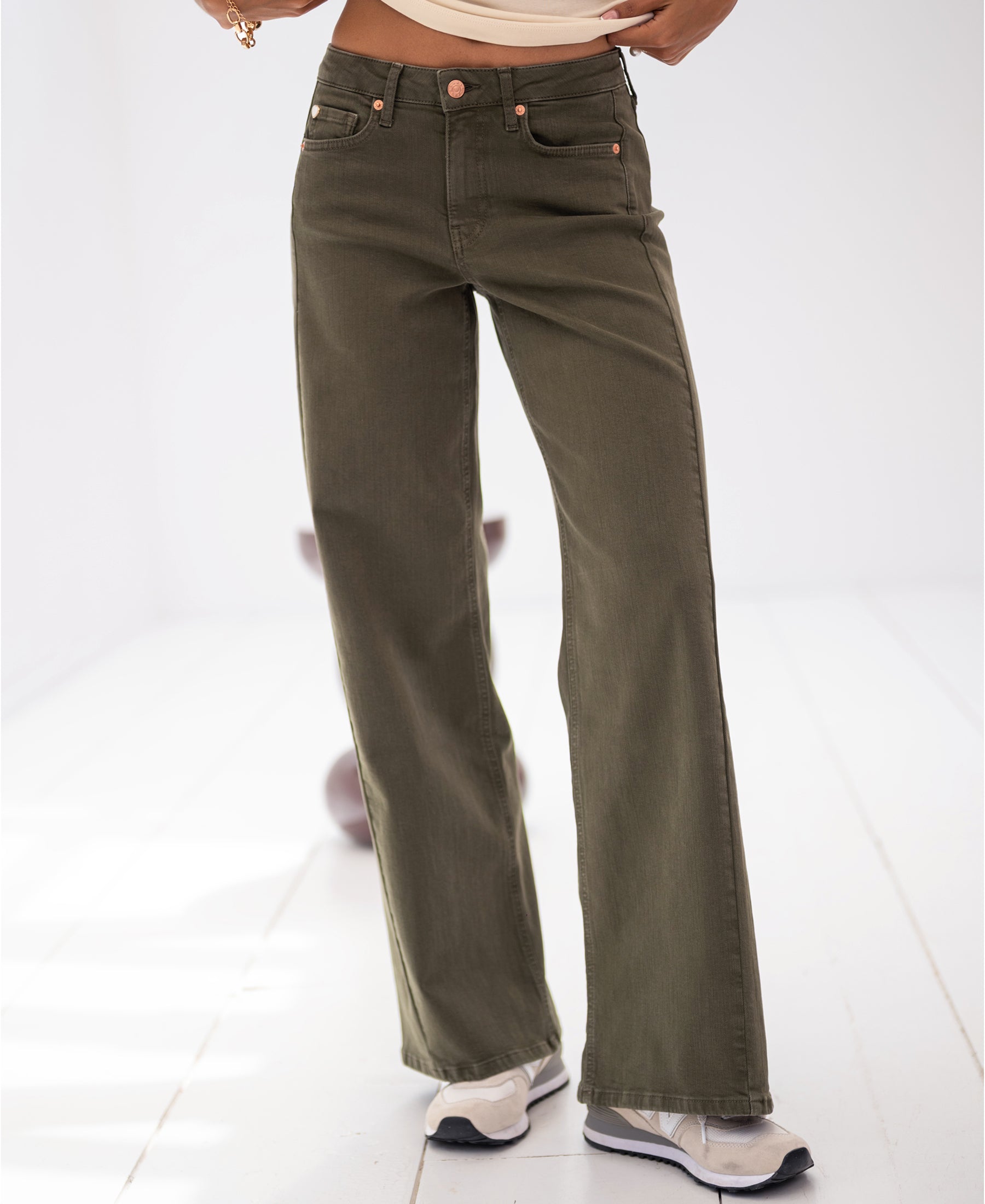 Wide-leg jeans in army green, shown on a person standing on a light-colored floor.