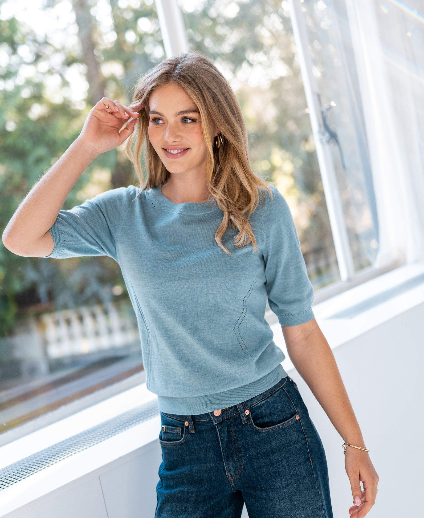 Light blue PLEIN PUBLIQUE LA STEF sweater shown on woman with long blonde hair.