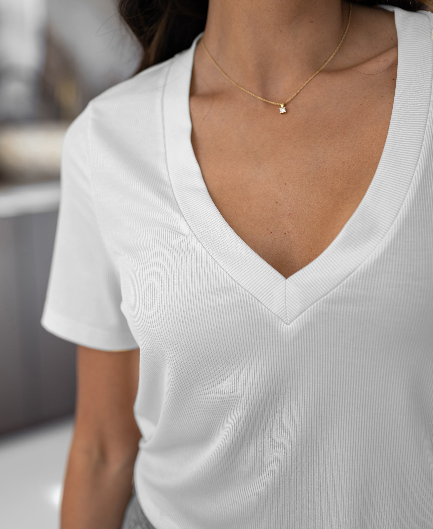 Woman wearing a relaxed-fit white Lyocell T-shirt, shoulders down.