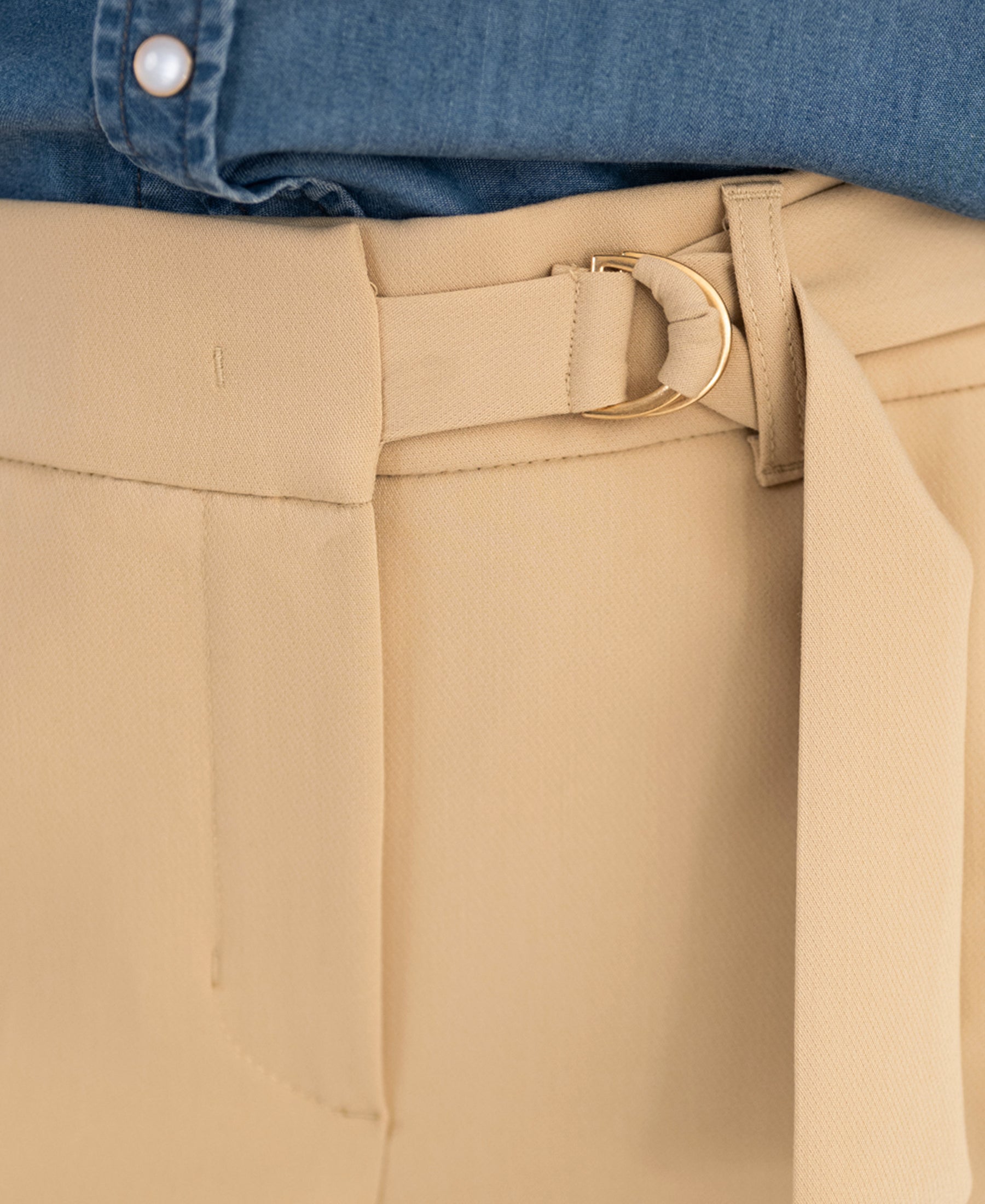 Close-up of LA WENDE beige stretch pants with gold buckle by PLEIN PUBLIQUE.