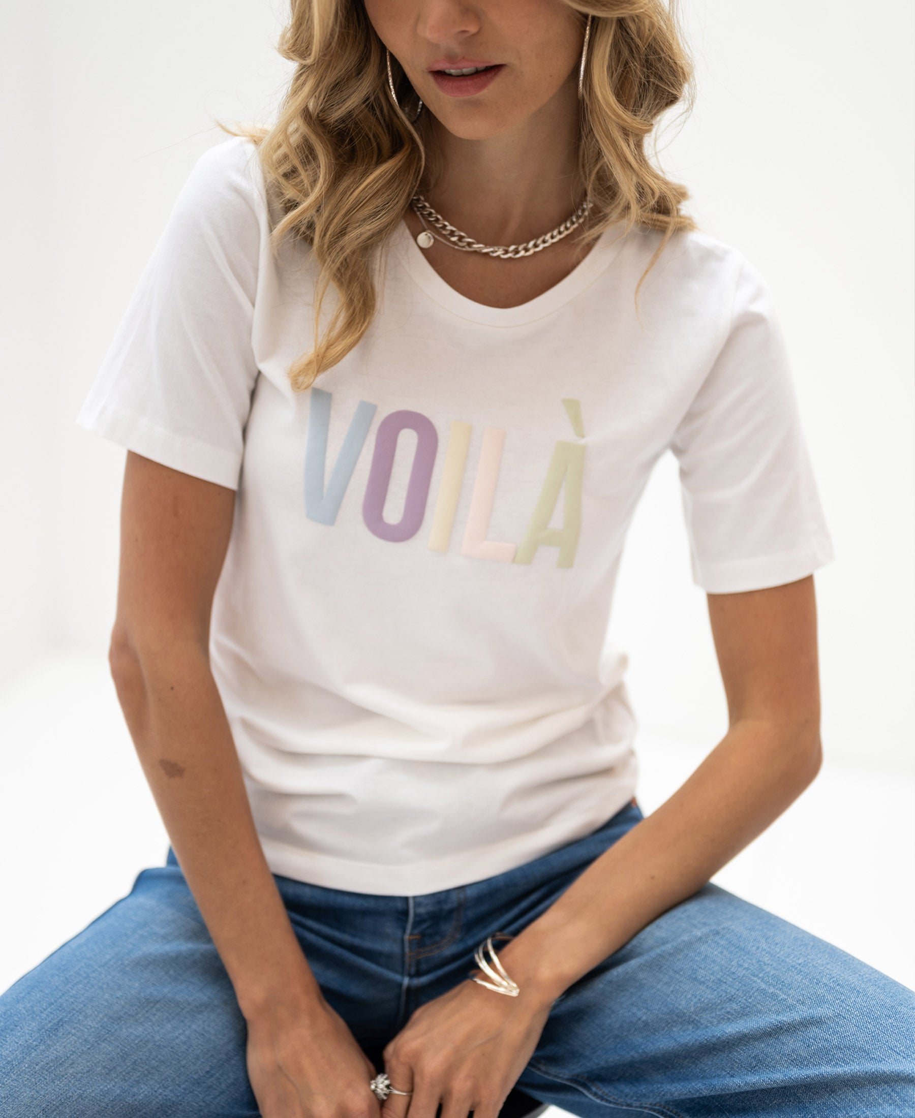 Woman wearing a white LA QUINTY Voila T-shirt.