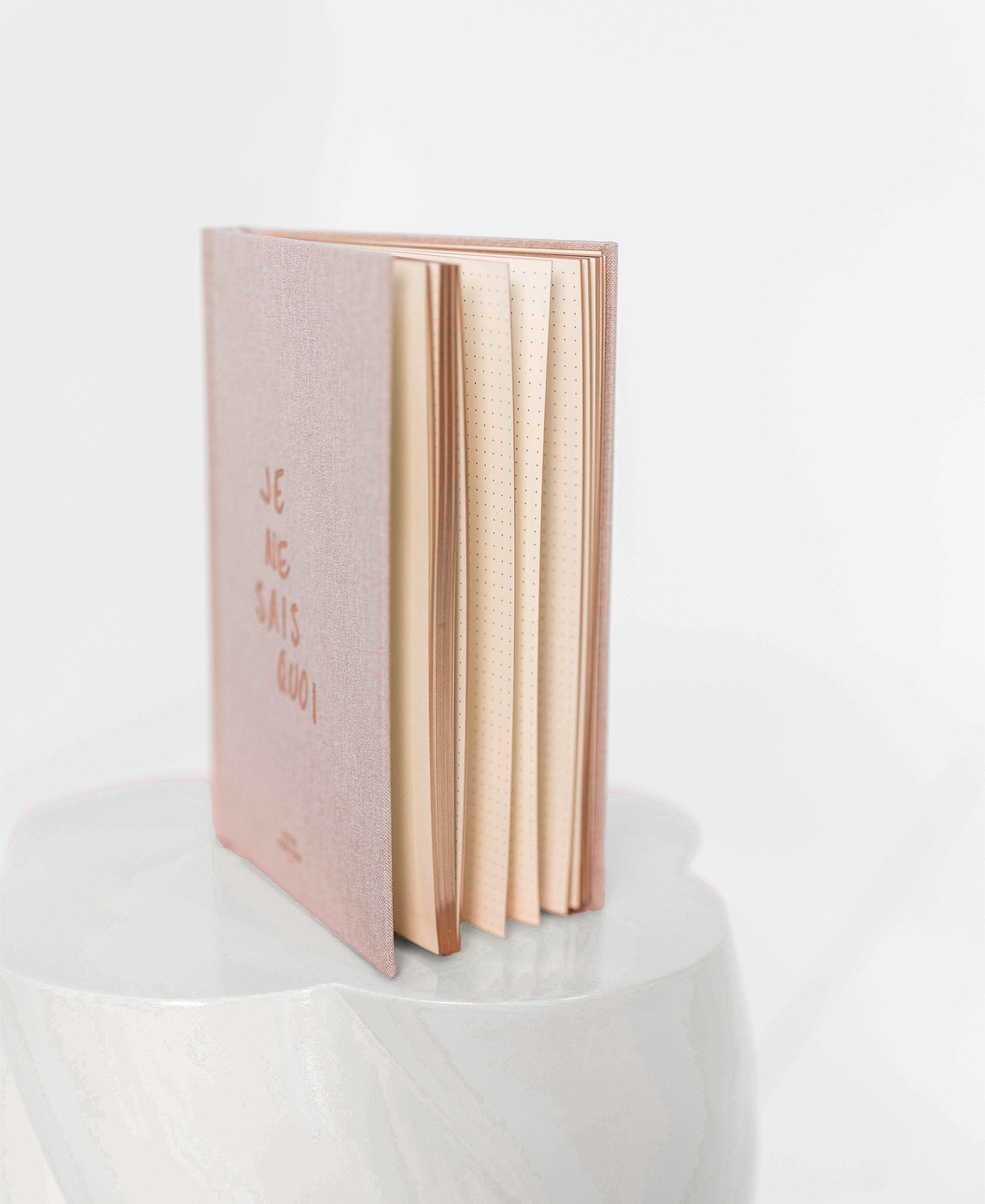 A natural A5 notebook titled "I Don't Know What" stands open on a rounded, glossy white surface.