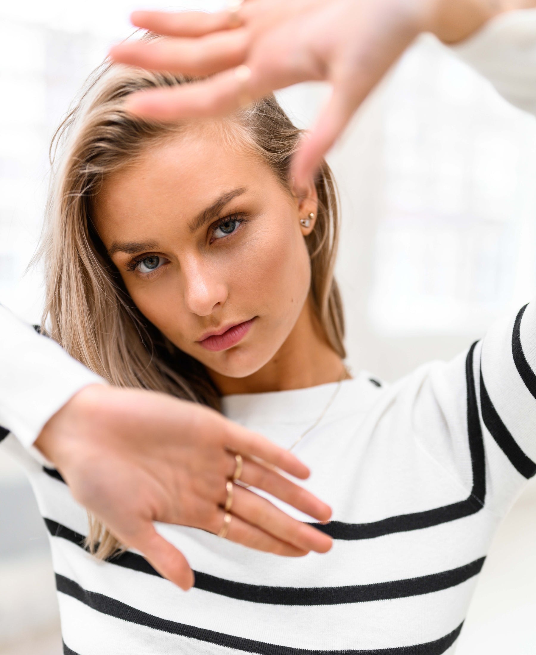Woman wearing the PLEIN PUBLIQUE Breton striped sweater L'ELISA in ivory-black, front view.