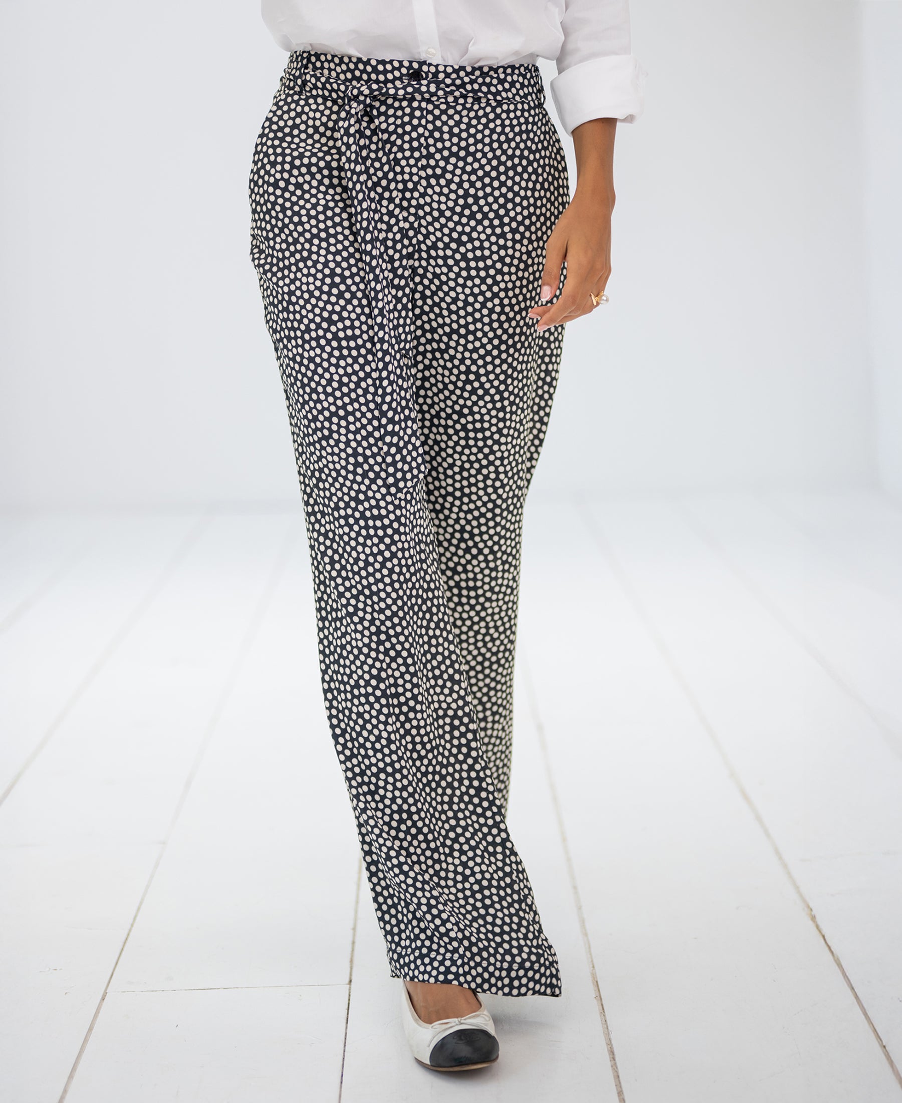 Charcoal-ivory dotted pants, full length, shown on a model standing on a white floor.