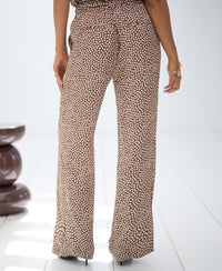 Wide-leg mocha and cream pleated pants shown on a white floor.