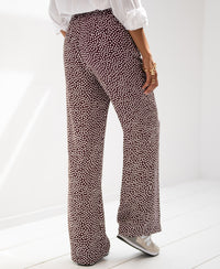 Woman’s polka dot pants in wine and ivory, shown indoors.