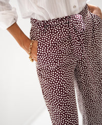 Woman wears Wine-Ivory polka dot pants, hand in pocket.