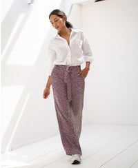 White LES ANDELYS wine-ivory polka dot trousers from PLEIN PUBLIQUE shown in a sunlit, minimal room.