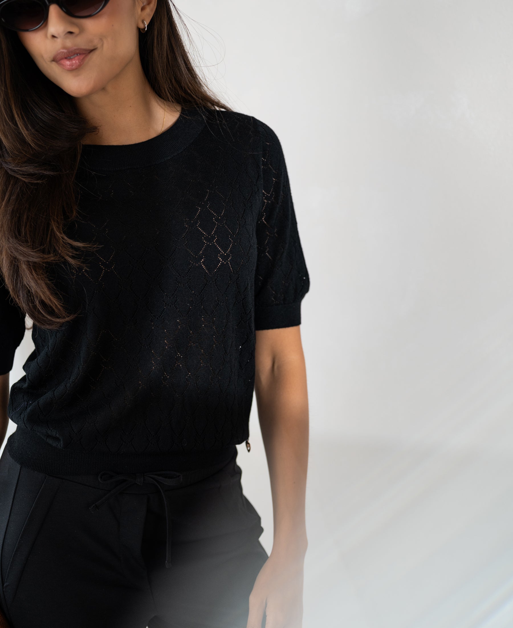 Black sweater with heart pattern by PLEIN PUBLIQUE, shown against a plain background.