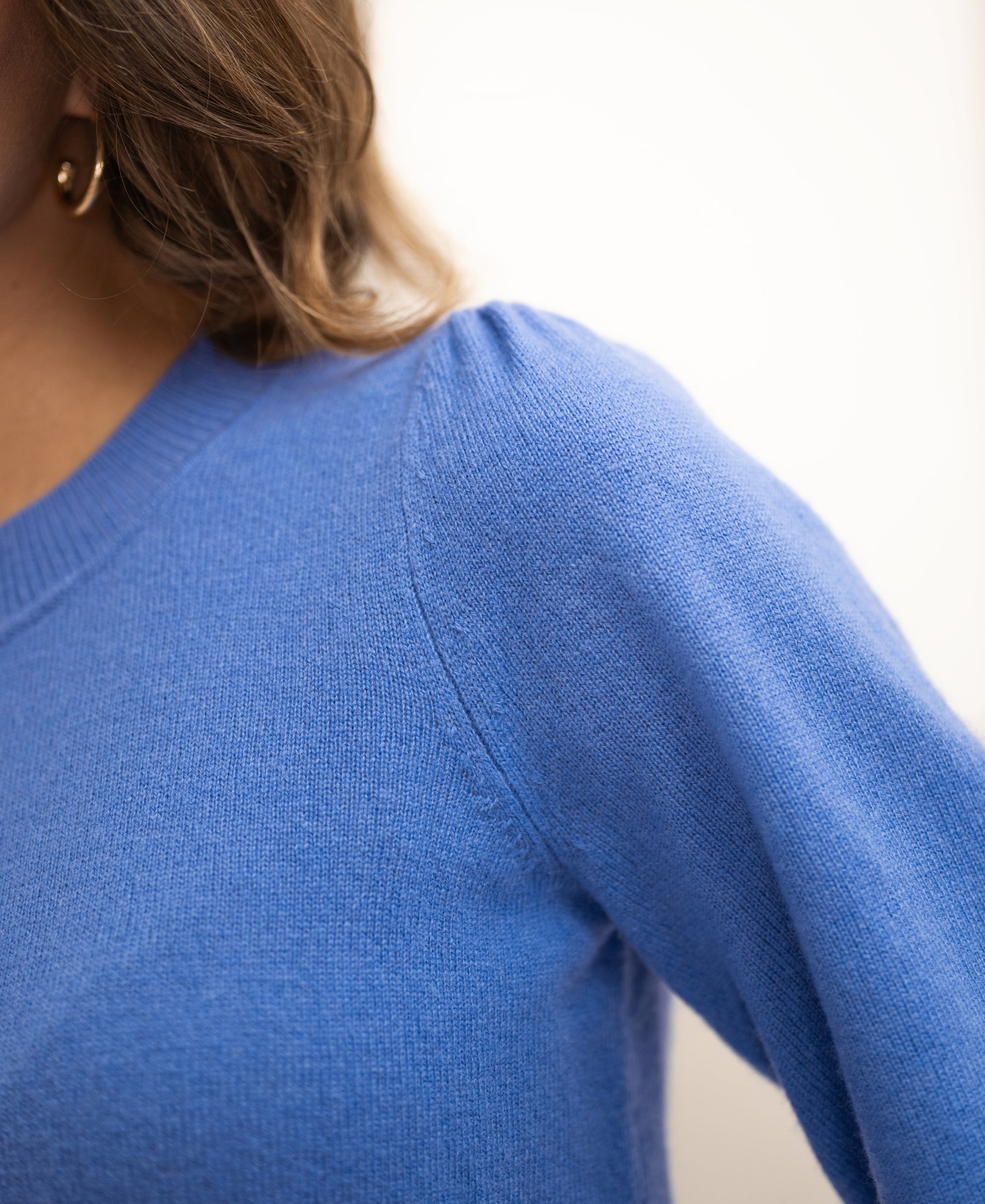 Close-up of soft merino wool sweater LA BAYONNE in lavender by PLEIN PUBLIQUE, showing blue knit shoulder and sleeve.