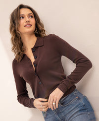 Woman wearing Merino wool polo shirt LE BOBIGNY Cacao by PLEIN PUBLIQUE, standing against a light wall.