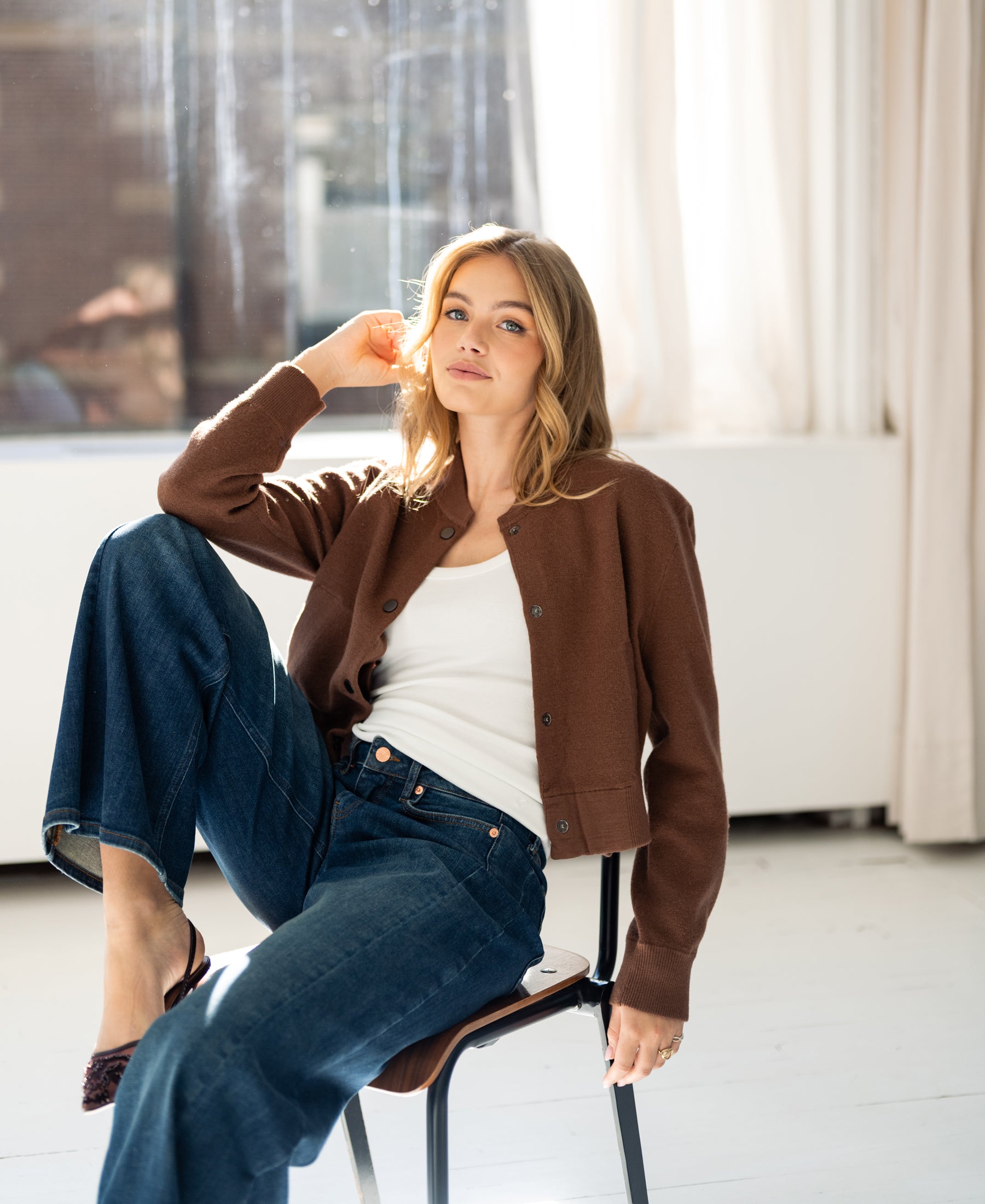 Camel bomber jacket in a sunlit room.
