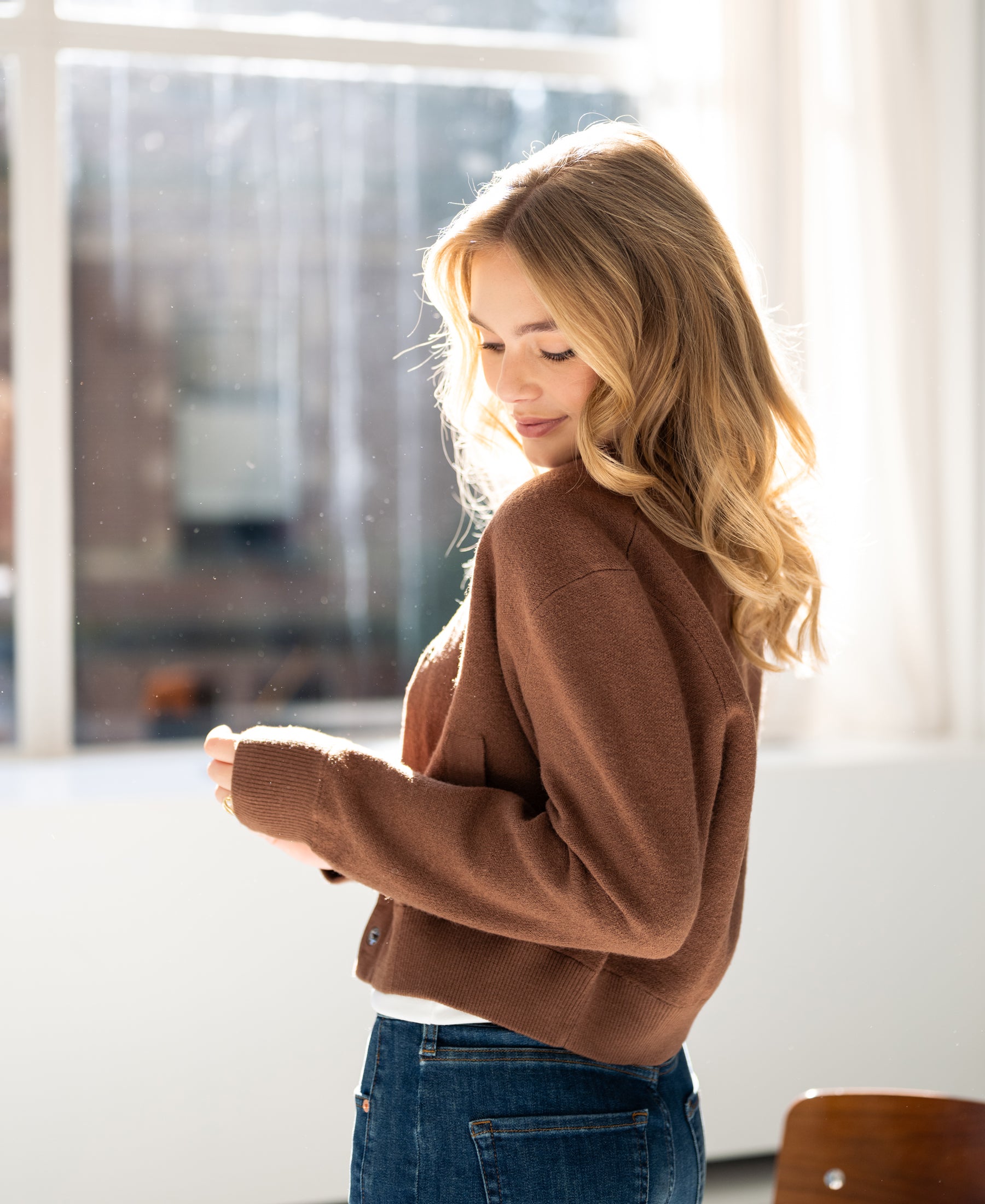 Camel-colored bomber jacket in sunlight.
