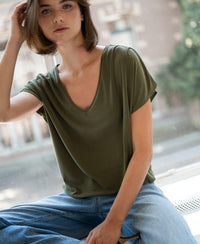 Olive green ribbed T-shirt, front view, modeled by a woman with short brown hair.
