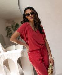 Red ribbed T-shirt in the style "The Good" by Plein Publique, shown indoors.