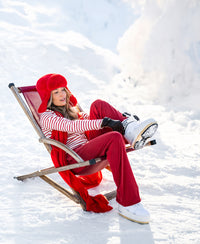 Woman wears coral red PLEIN PUBLIQUE LA BELLA Merino wool wrap shawl in the snow.