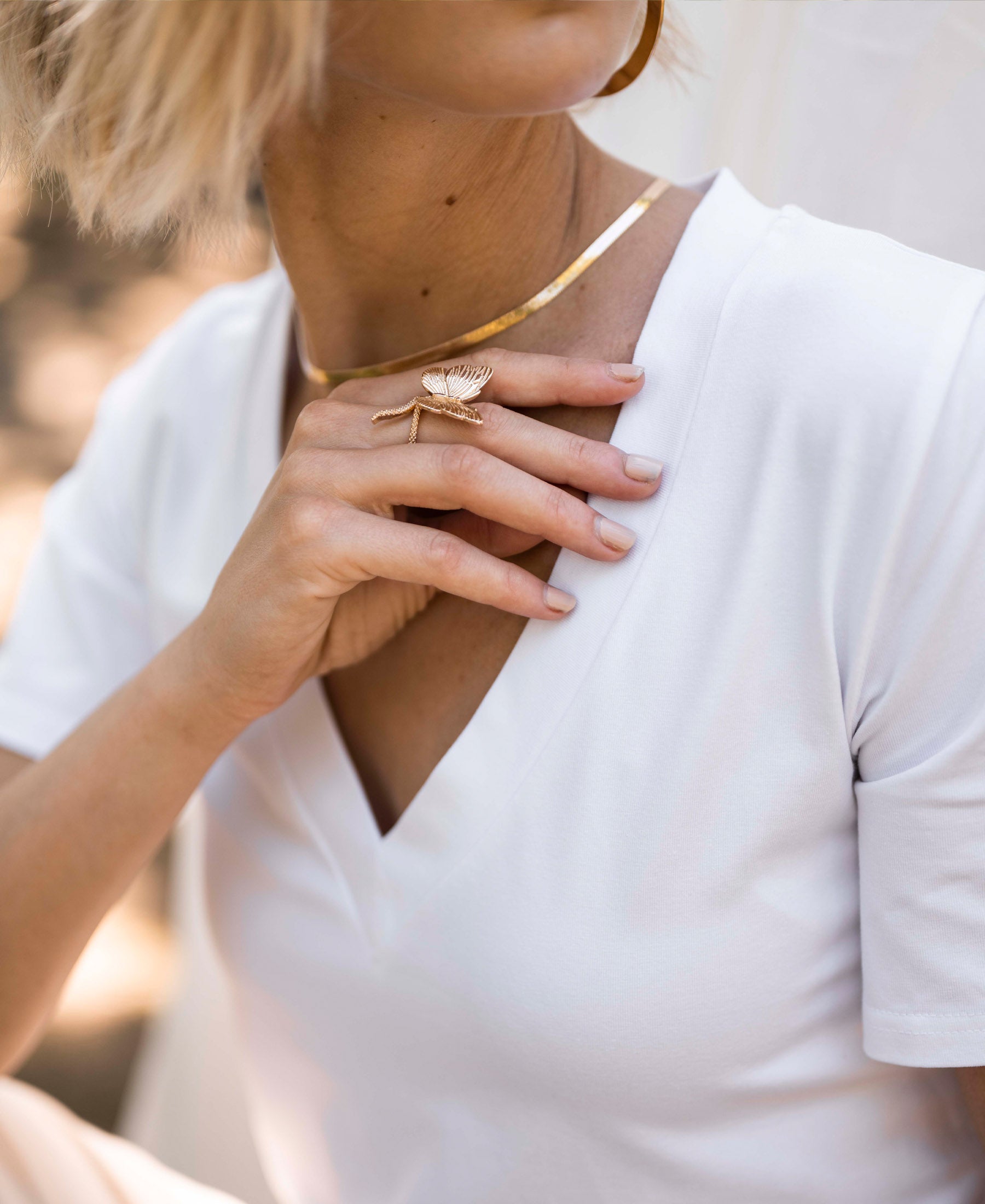Woman wears a PLEIN PUBLIQUE V-neck LA VIDA white T-shirt.