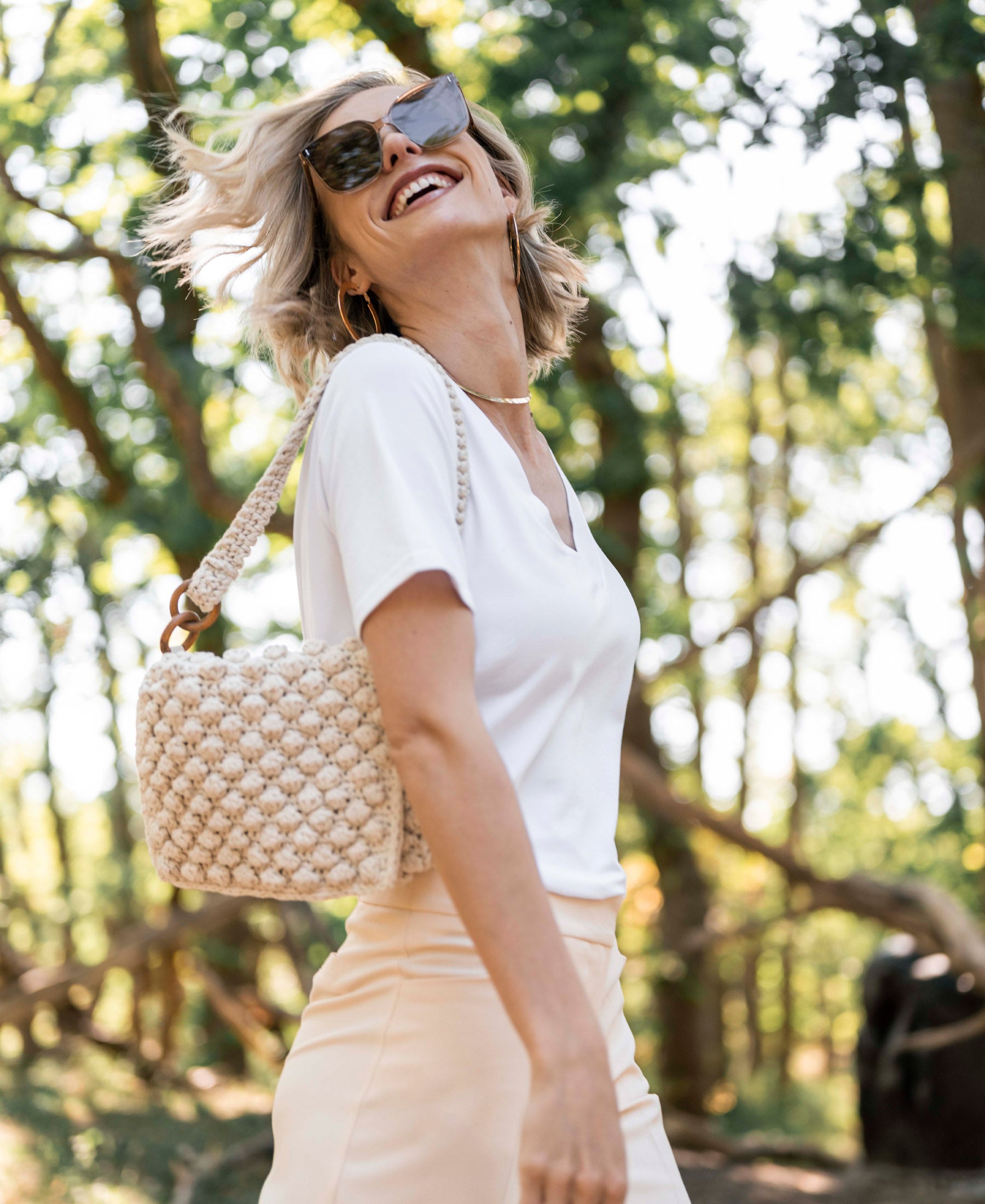 White V-neck LA VIDA T-shirt by PLEIN PUBLIQUE, shown outdoors among trees.