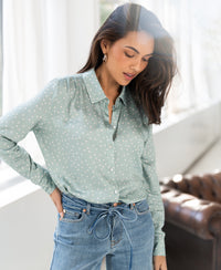 Light green and ivory polka dot blouse by PLEIN PUBLIQUE, shown worn indoors, model looking down.
