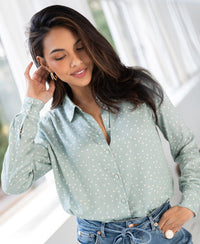 Woman wearing a Plein Publique LA SEZANNE polka dot blouse in mist green and ivory, lit by natural window light indoors.