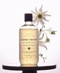 A bottle of Plein Publique delicate laundry detergent Bondi Wash Blue Cypress & Petitgrain on a table.