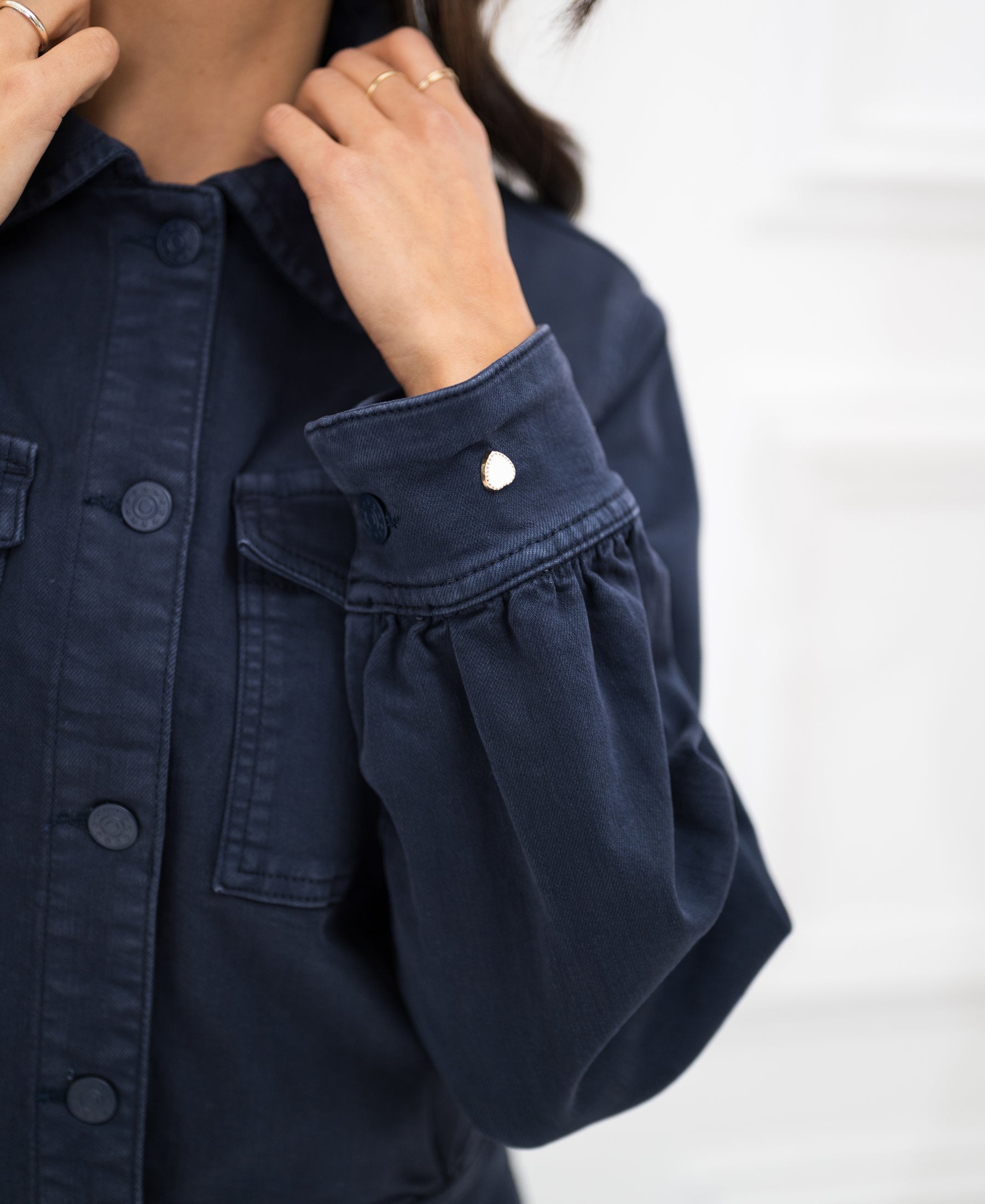 Dark blue stretch denim jacket, model holding the collar.