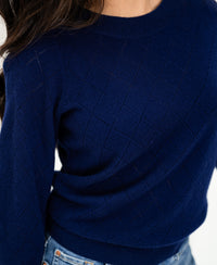 Navy argyle merino wool sweater, shoulders to waist visible.