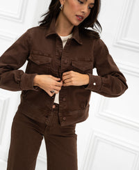 Stretch denim jacket in cacao color against a white paneled background.