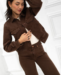 Stretch denim jean jacket in brown on a woman, shown against a white paneled background.