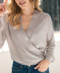 Sand-colored wrap sweater LES CINQ by PLEIN PUBLIQUE worn indoors with sunlight on face.