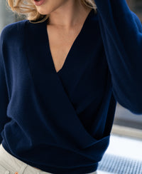 Navy PLEIN PUBLIQUE wrap sweater LES CINQ, partially visible on model with loose blonde hair.