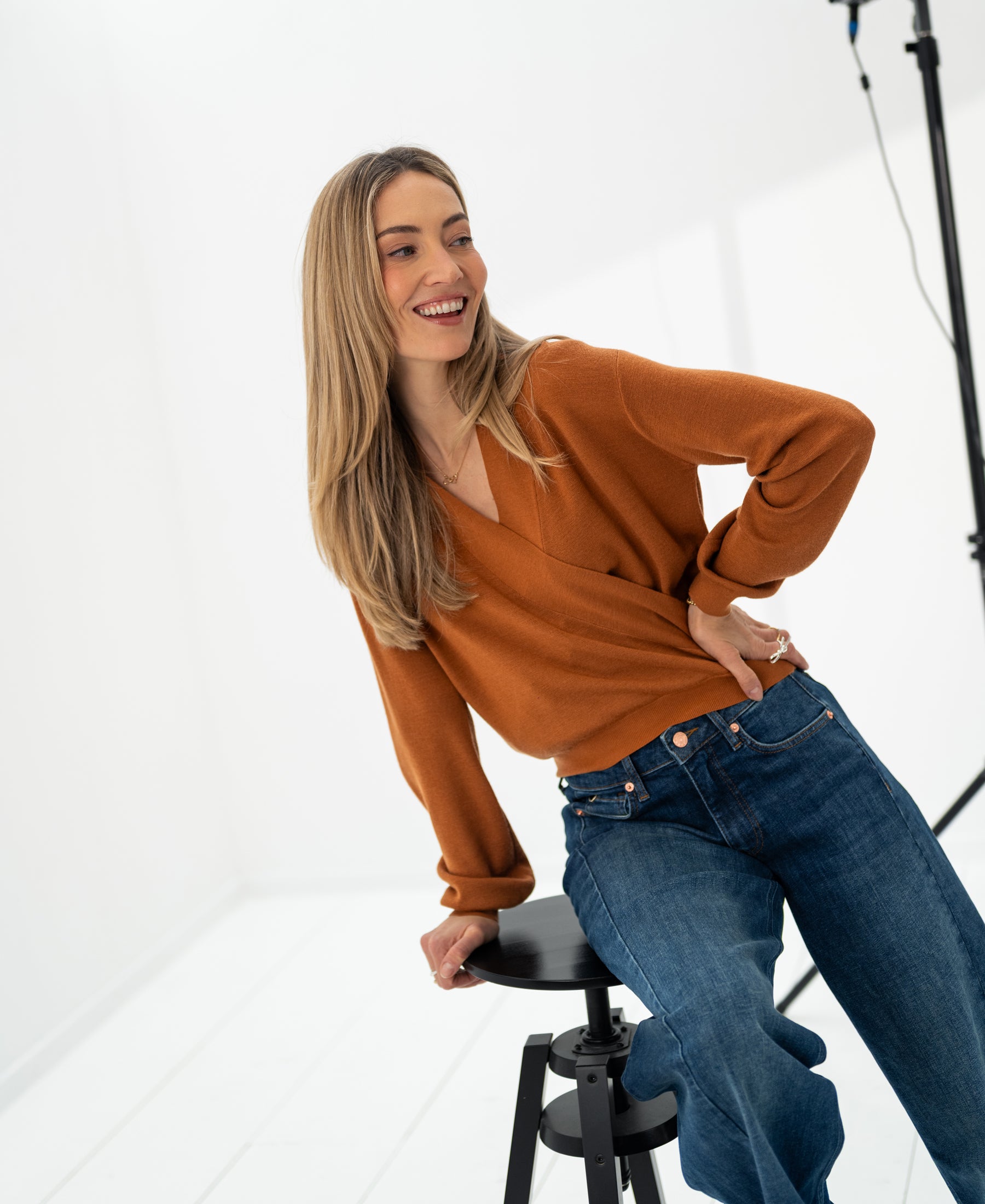 Woman wearing the LES CINQ Terra wrap sweater in terra color by PLEIN PUBLIQUE.