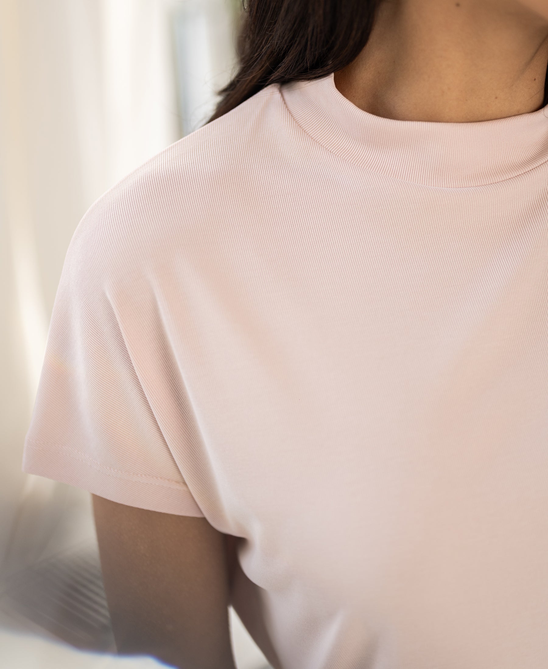 Blush pink ribbed collar top in a shoulder-up view.