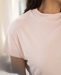 Blush pink ribbed collar top in a shoulder-up view.