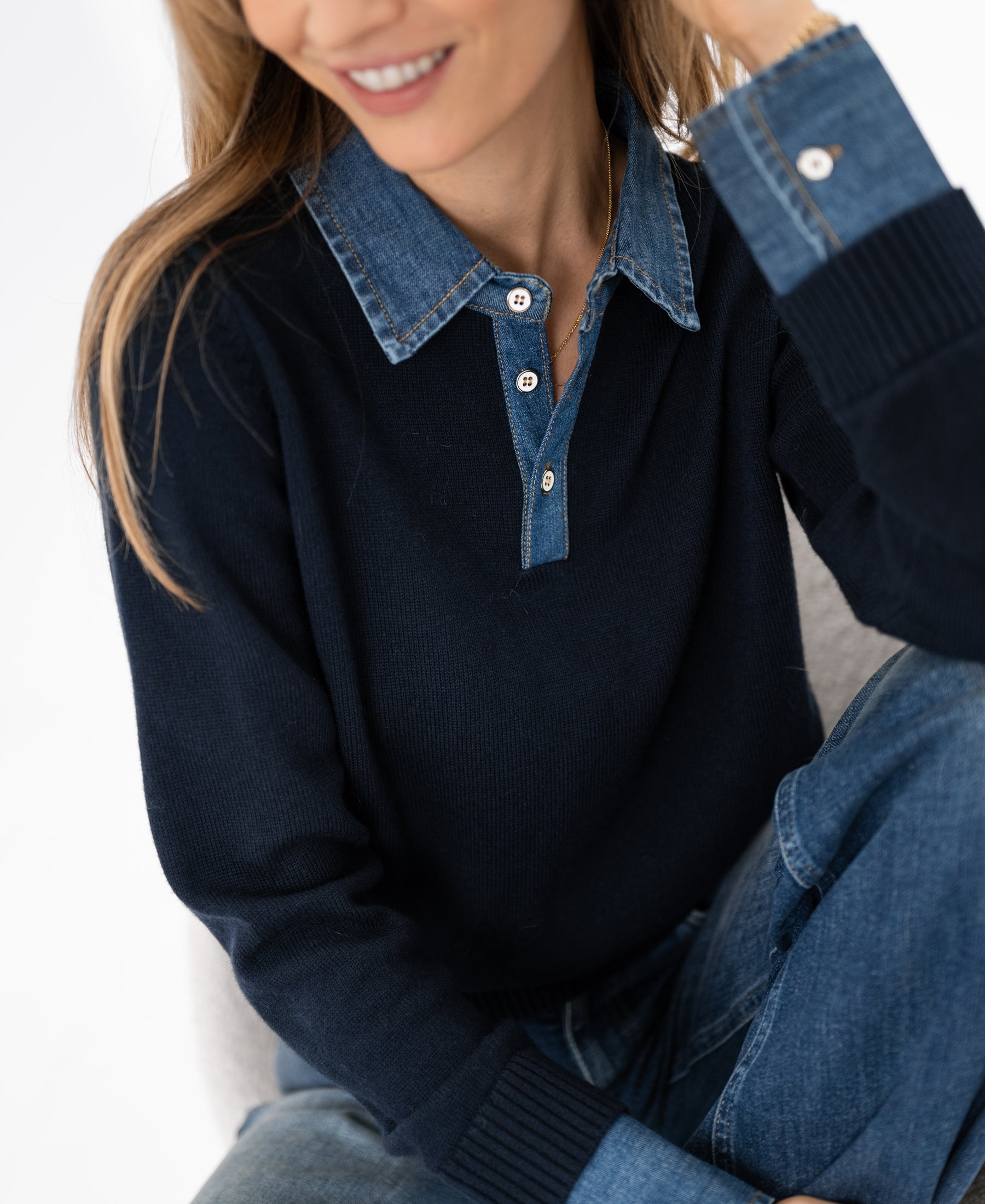 Dark blue PLEIN PUBLIQUE LA COLLEGE sweater-blouse, modeled with a partial view of the wearer’s face.