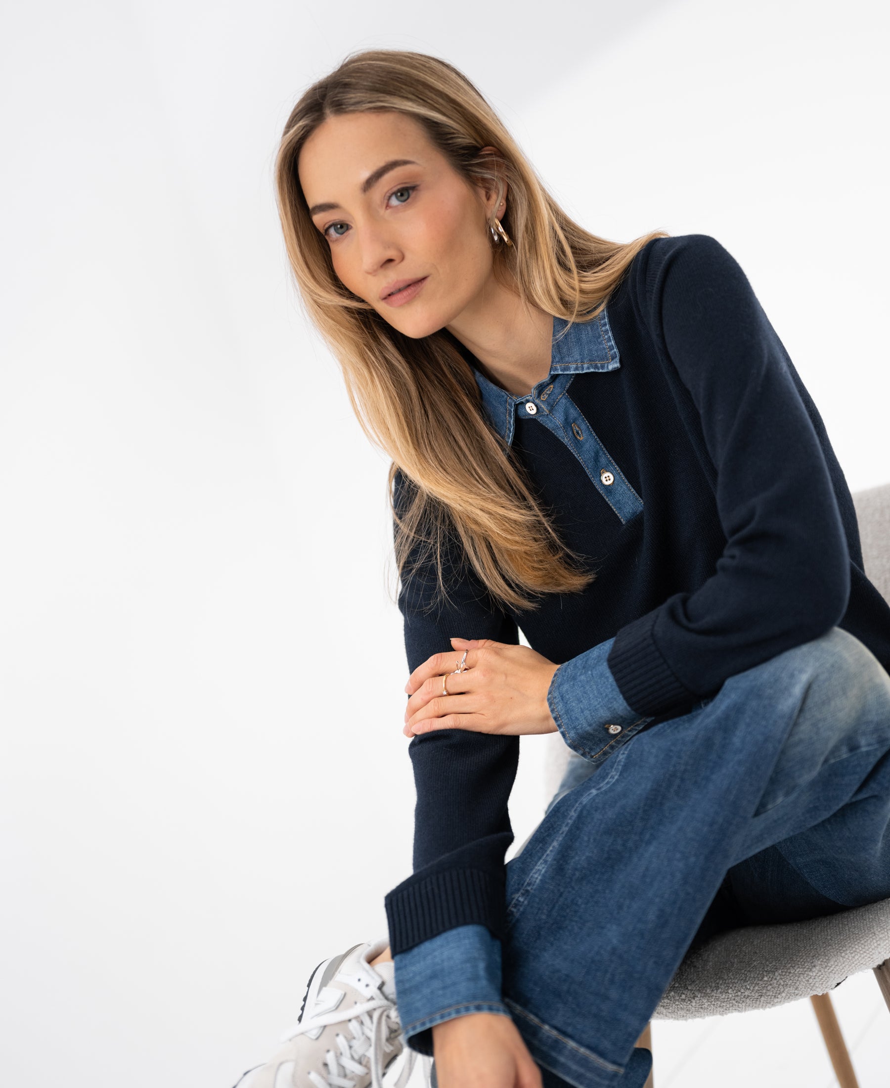 Navy blue PLEIN PUBLIQUE LA COLLEGE knit blouse shown on a seated model.