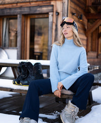 Light blue PLEIN PUBLIQUE LA COZY turtleneck sweater displayed outdoors in a snowy setting.