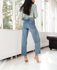 Cropped light stonewash jeans, styled indoors.