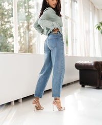 Light stone blue cropped jeans shown in a bright modern room.