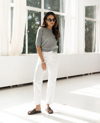 Cropped white denim jeans LE DEAN shown in a bright room with large windows.