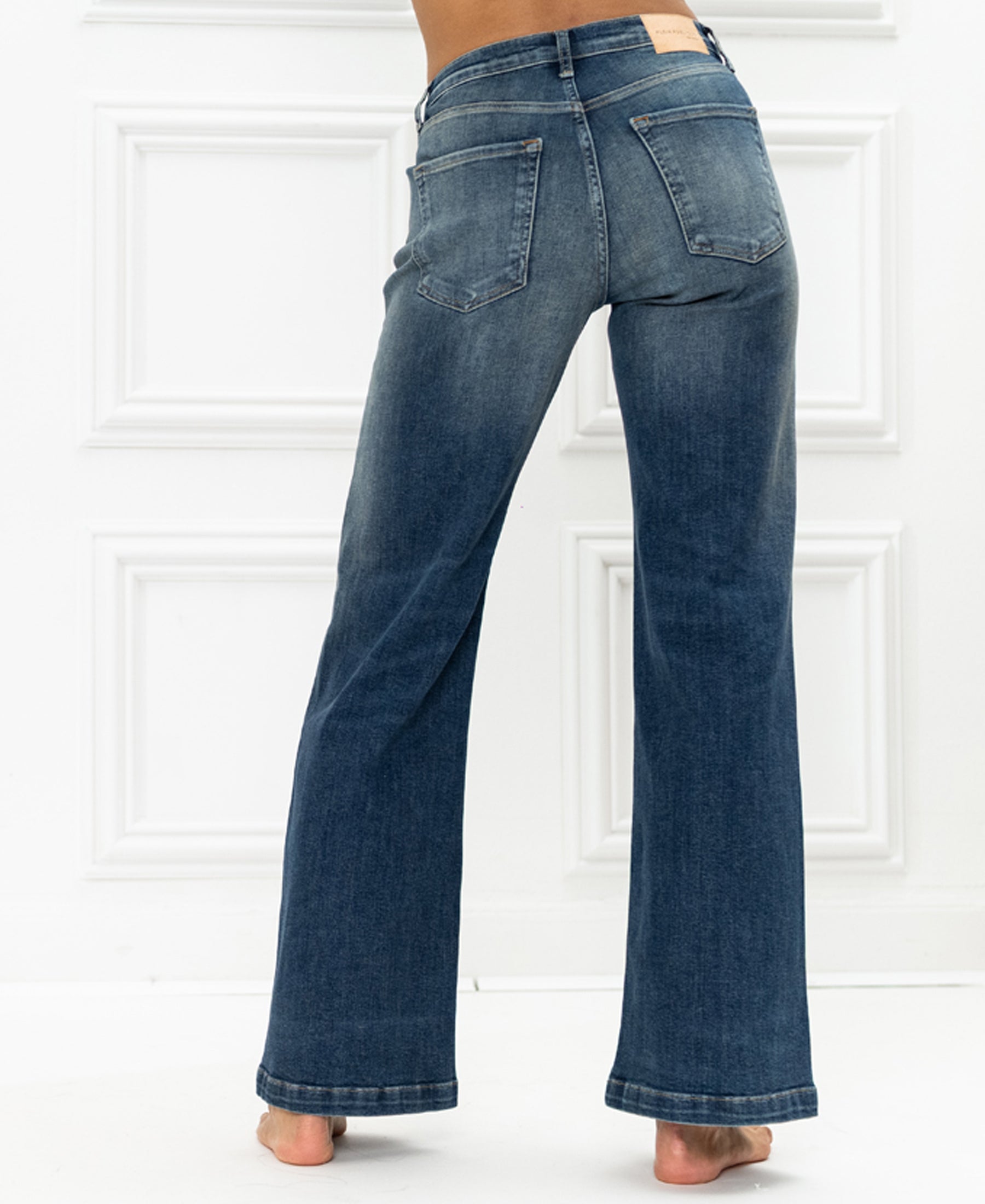 Wide leg blue jeans by Plein Publique, shown from the back on a white background.