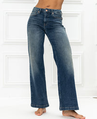 Wide leg blue vintage jeans by Les Deux against a white paneled background.