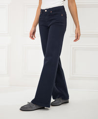 A person wearing dark blue LES DEUX jeans stands in a bright white room.