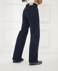 Dark blue LES DEUX jeans shown from the back in a white room.