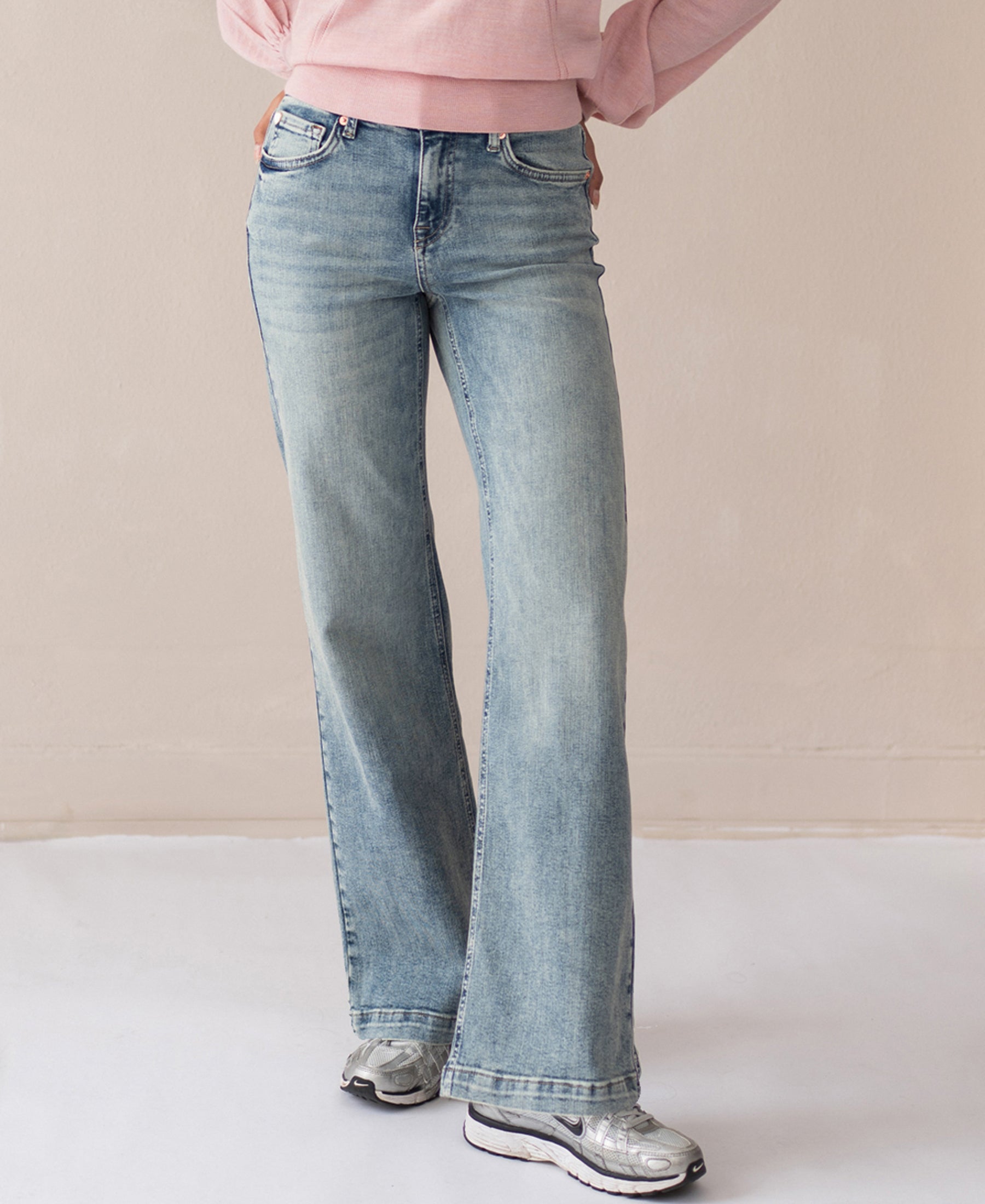Person wearing vintage wide leg jeans indoors.