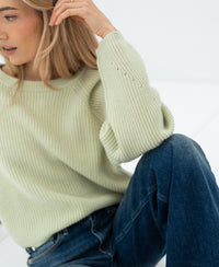 Woman wearing a LE DIJON light green merino wool sweater by PLEIN PUBLIQUE.