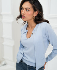 Light blue PLEIN PUBLIQUE LA DOUBLE knit vest shown on a woman indoors by a white wall, side view.